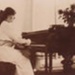 Louise Schmidt playing a grand piano in the Hampton Hotel; c. 1914; P0308